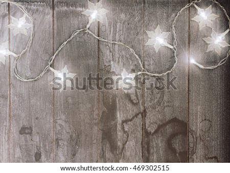 christmas lights as white glowing  stars on wood