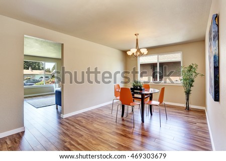 Modern dining area with orange chairs and glass table. Northwest, USA