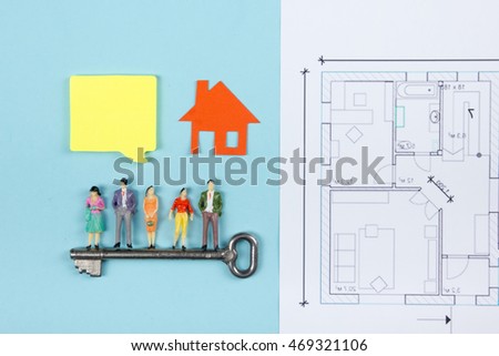 Real Estate concept. Construction building. Blank speech bubbles, people toy figures, paper model house, blueprints with key on blue architect desk table background. Top view. Copy space for ad text.