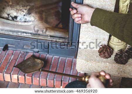 Man is going to clean the fireplace. Open the door and keep the blade

