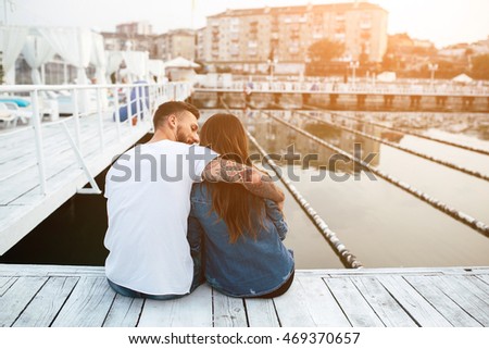 beautiful couple posing on a wooden pier at lake