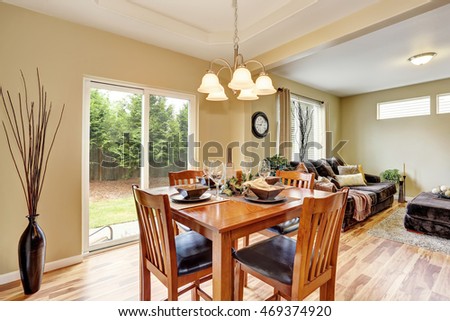 Dining area with wooden table set connected to living room. Northwest, USA