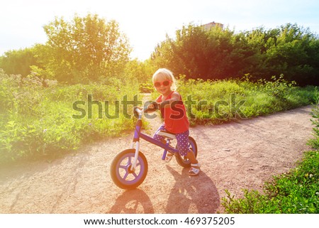 little girl riding bike in summer nature, active kids