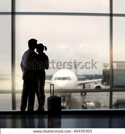 silhouette of pair of lovers near the window in airport Royalty-Free Stock Photo #46939303