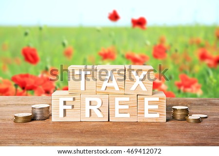 Text tax free on wooden blocks with stacked coins. Financial concept.