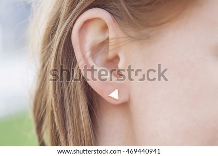 Woman ear wearing beautiful luxury earring Royalty-Free Stock Photo #469440941