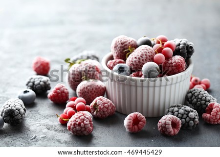 Frozen berries on a black wooden table