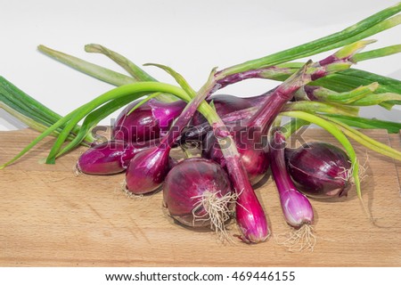 red onions on a wooden cutting board and white background