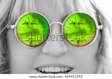 Close up of a Woman wearing reflective sunglasses with reflection of the airplane
