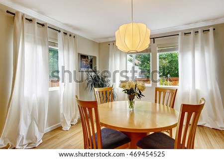 Cozy dining area with table set and curtains in creme tones. Northwest, USA