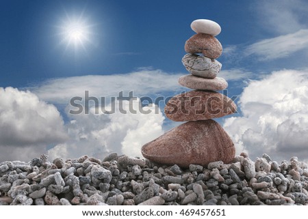 Balance stone on pile rock with blue sky background for concept of Zen and calm.