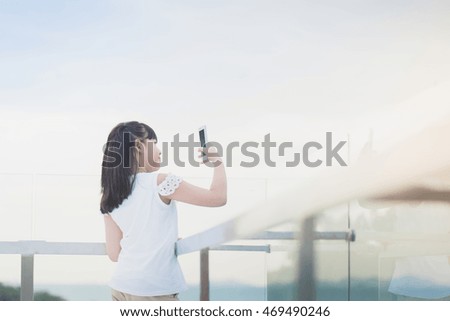 Beautiful Asian girl use smart phone taking photo outdoors