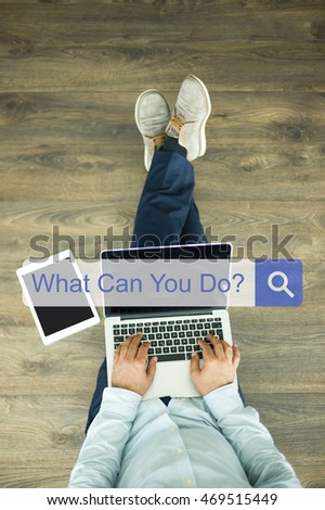 Young man sitting on floor with laptop and searching WHAT CAN YOU DO? concept on screen