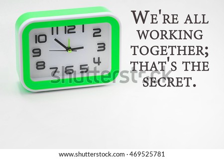 Conceptual image with word WE'RE ALL WORKING TOGETHER; THAT'S THE SECRET view of green clock on the white background. quotes concept. copy space