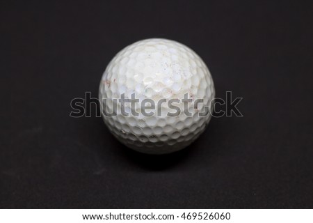 Used dirty golf ball on the black background