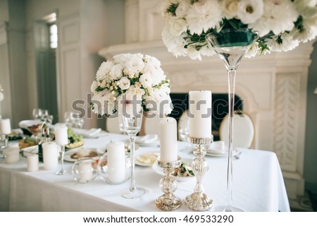 Table decor with white flowers  and candles for an event party or wedding reception Royalty-Free Stock Photo #469533290