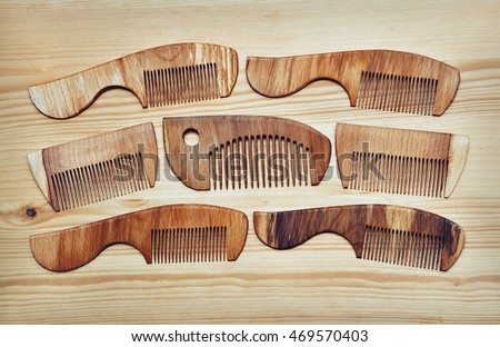 many wooden comb on a wooden background. a natural material, means of personal hygiene