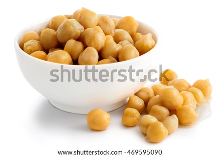 Cooked chickpeas in white bowl on white. Spilled chickpeas. Royalty-Free Stock Photo #469595090