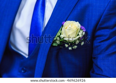 Very beautiful buttonholes on the jacket of a young and handsome groom