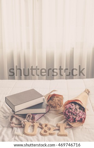 you and i wood alphabet with the bouquet of dried flower and book on the bed. romantic concept