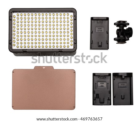 On-camera LED video light kit flat lay. Video Light, tungsten filter, mounting thread, adapters for battery. On white background.
