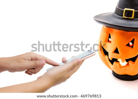 Man use mobile phone, Pumpkin lantern as background.