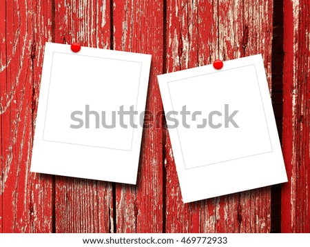 Close-up of two blank square instant photo frames with pins on red weathered wooden boards background