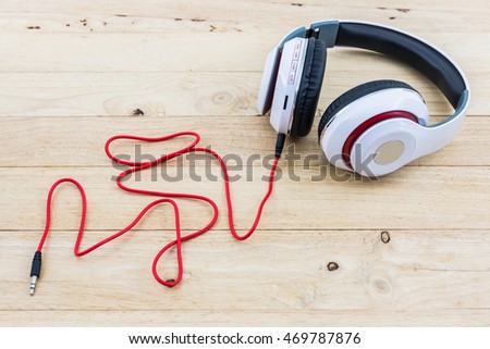 White Headphones on wood desk background. 