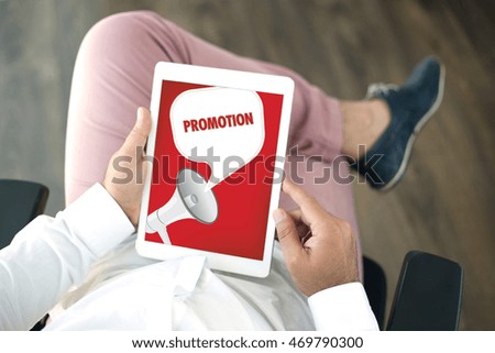 People using tablet pc and PROMOTION announcement concept on screen