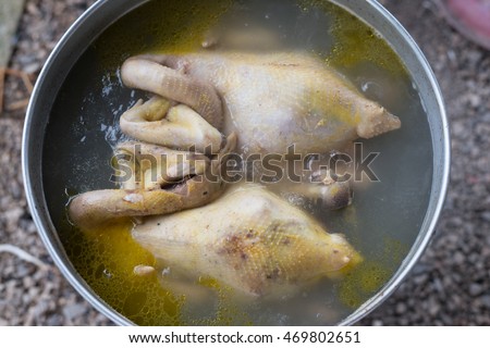 Boiled chicken in a pot of boiling water.
