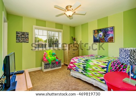 Adorable kids room in green color with bright colorful bedding and beige carpet  floor .Northwest, USA