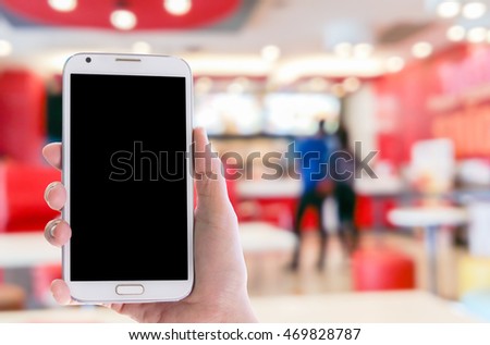 Man use mobile phone, blur image of ice cream shop as background.