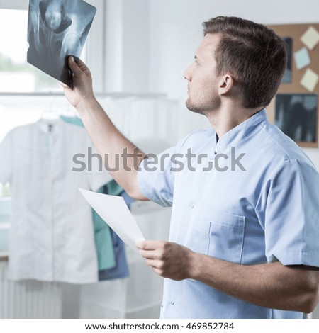Male experienced physiotherapist checking the xray photo