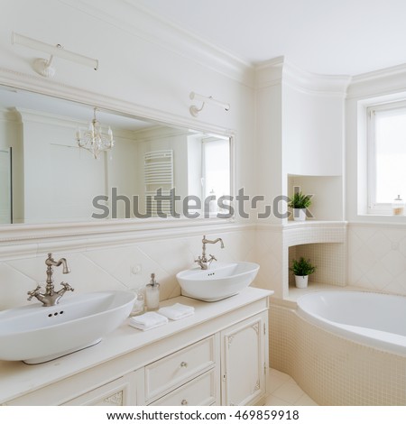 Horizontal picture of a showy bathroom designed in creamy colors