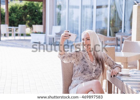 beautiful girl in restaurant is photographed on the phone