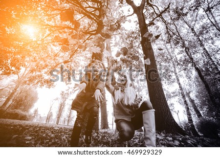 mother and daughter playing together in the autumn park