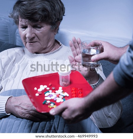 Picture of an old woman refusing to take her medication