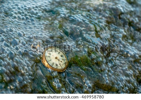 The passage of time. Water flowing over an old pocket watch. For Puzzle, tie, canvas, acrylic and framed prints.
