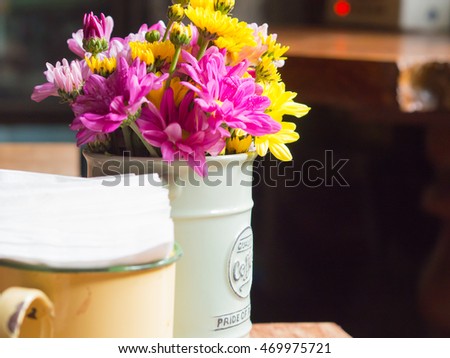 Vase with iron and flowers, vintage style on the table in coffee shops.
