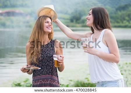 Two young girls enjoy in nature ner lake.Colored and Under exposed photo
