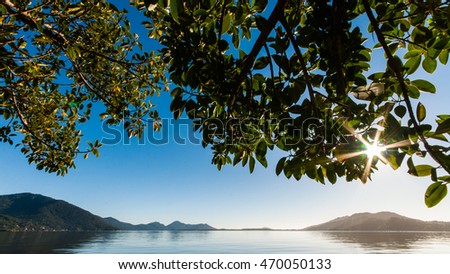 Sunburst in Florianopolis, Brazil by Lake and Mountains Royalty-Free Stock Photo #470050133