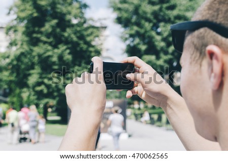 Man tourist taking photo with mobile phone