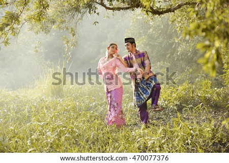 Asian man and woman wearing traditional dress Muslim in dancing action,vintage style ,Thailand