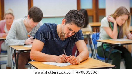 Students sitting in an exam hall doing an exam in university Royalty-Free Stock Photo #470081306