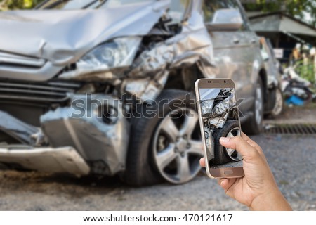 Close up hand of woman holding smartphone and take photo of car accident