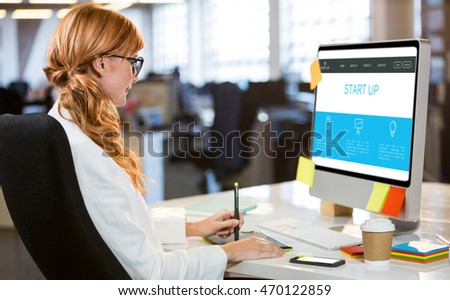 Startup homepage against businesswoman using graphics tablet at desk