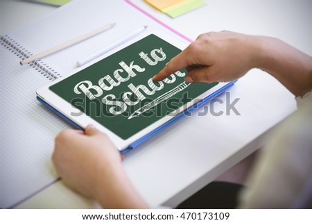 Back to school message against cropped image of businesswoman touching digital tablet at office