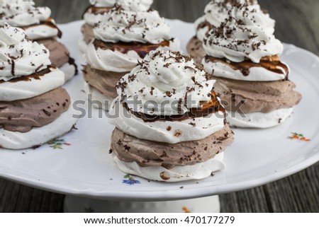 Detail on Traditional Czech sweet dessert "Manicka" - Meringue with chocolate whipped cream and whipped cream on a Plate on Old Wooden Board
