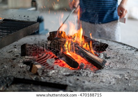 A man heating up a charcoal fire for grilling