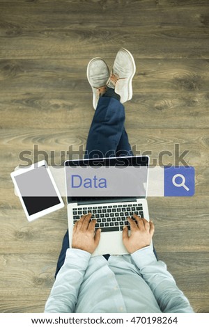 Young man sitting on floor with laptop and searching DATA concept on screen
